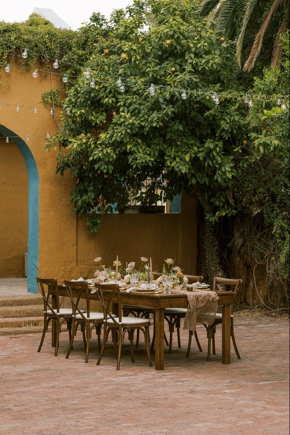 A garden wedding reception table set beneath a tree