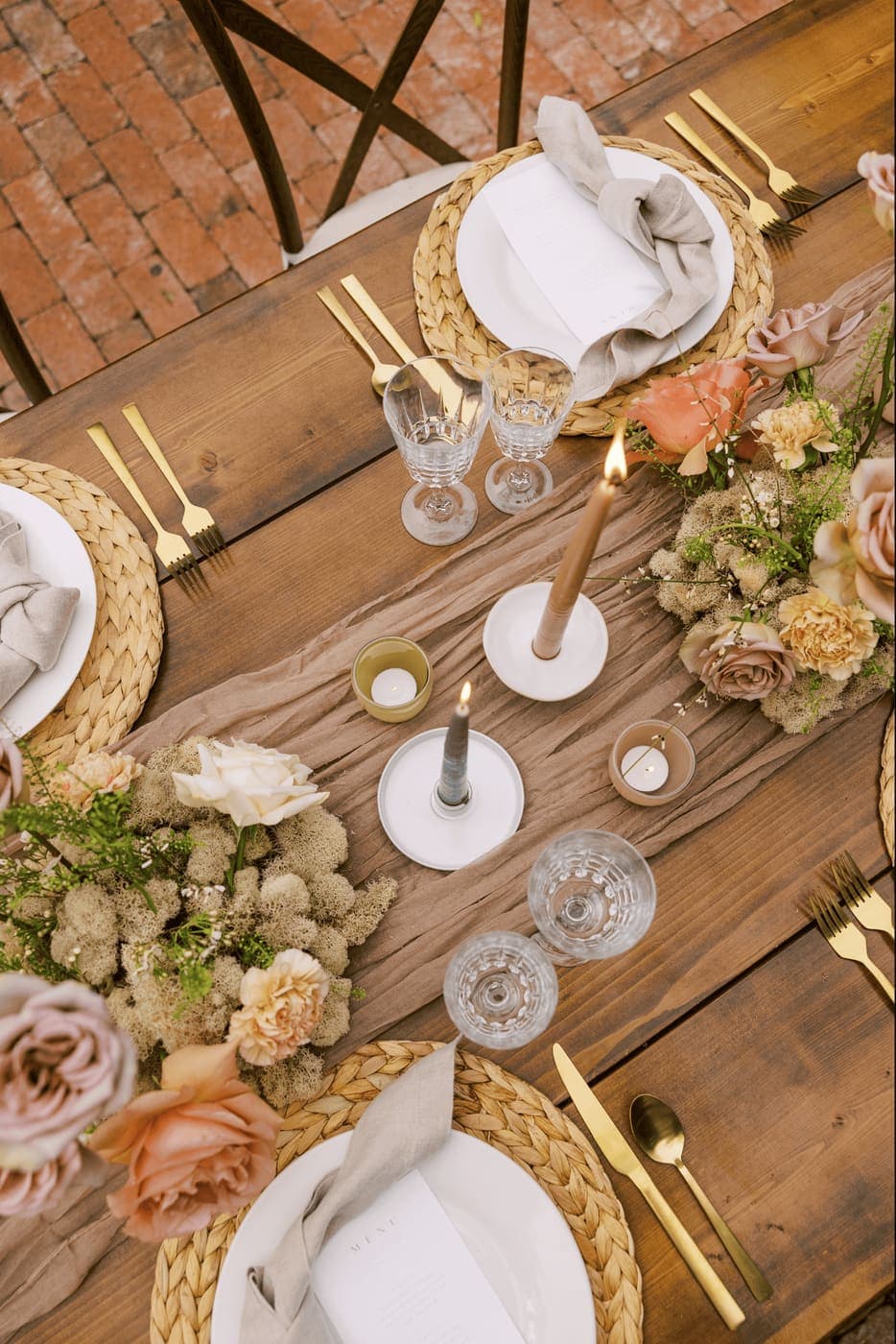 Close-up of wedding table details: candles, florals, and glassware