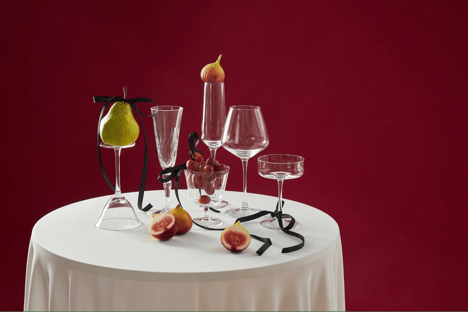 An elegant wedding dinner table set with wine glasses and seasonal fruit